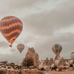 hot air balloons flying over rocky terrain